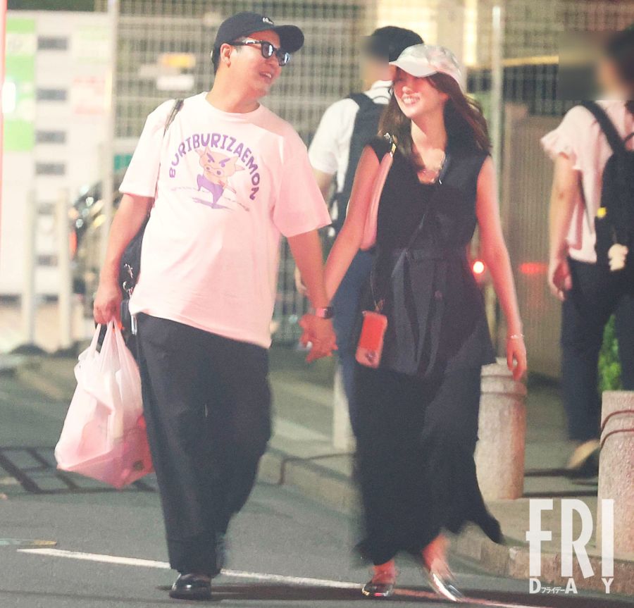 コットンきょんさんとまつきりなさんがスーパーで手を取り合い、笑顔を見せる新婚夫婦の姿