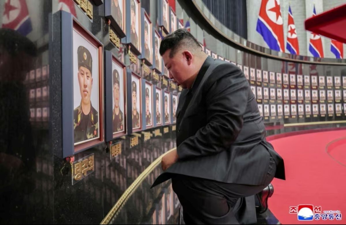 北朝鮮の金正恩総書記が、ウクライナ紛争でロシア軍を支援し戦死した自国兵士たちの追悼式典に出席し、遺影に表彰バッジを付けている様子。