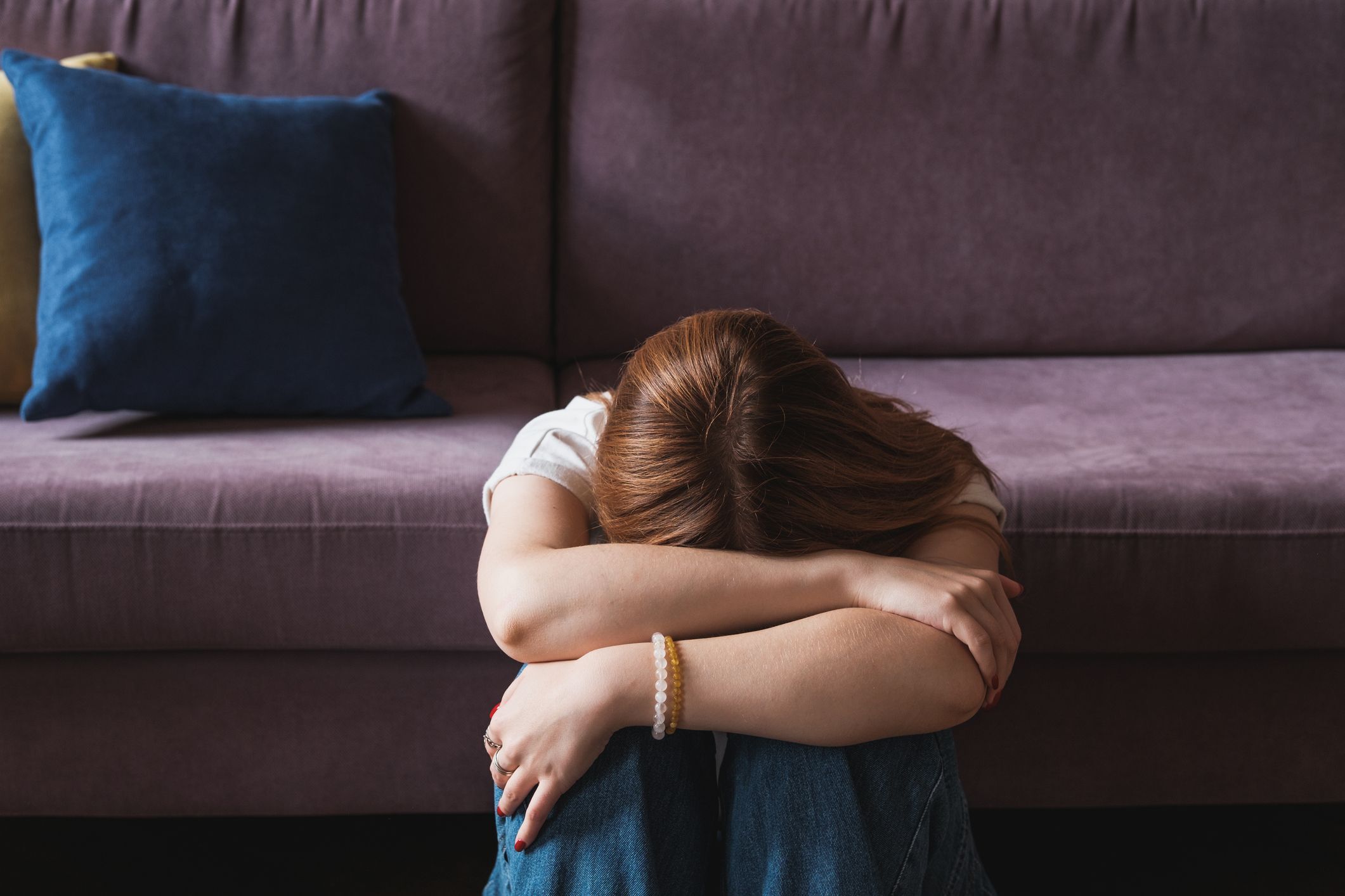 コロナ禍における家庭内暴力（DV）の増加と、移動制限による苦悩を表す女性のイメージ写真。自宅での孤立感やストレスが背景にあることを示唆しています。