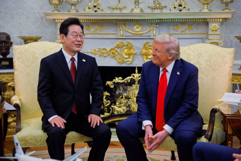ホワイトハウスでの米韓首脳会談で握手を交わすトランプ米大統領と李在明韓国大統領