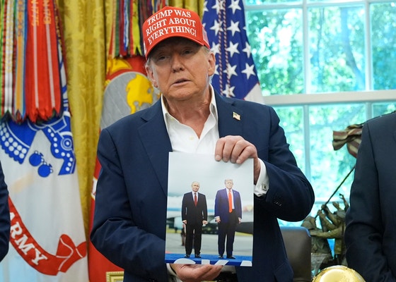 トランプ大統領がホワイトハウス執務室でアラスカ会談時のプーチン大統領との写真を見せる様子
