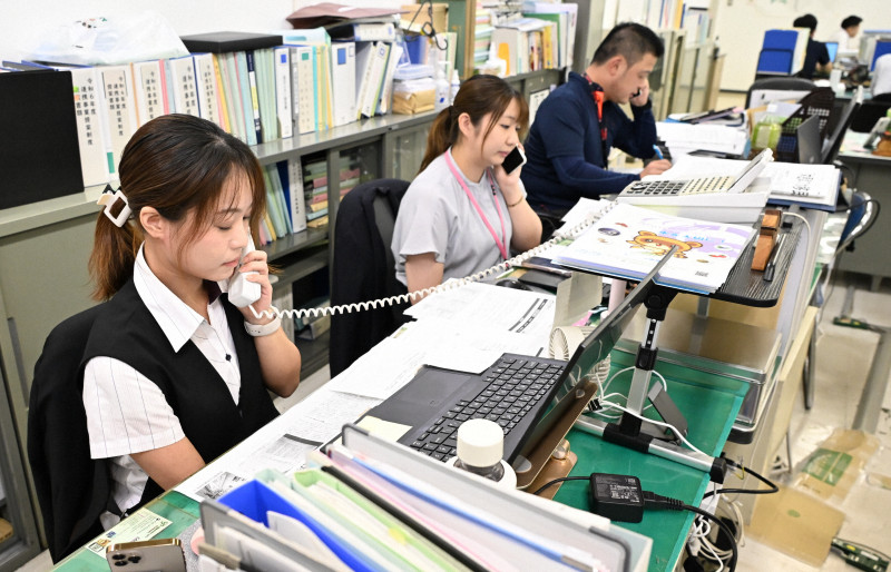 木更津市役所で住民からの問い合わせに対応する職員。JICAアフリカ・ホームタウンに関する誤情報が拡散し、不安の声が相次いでいる。
