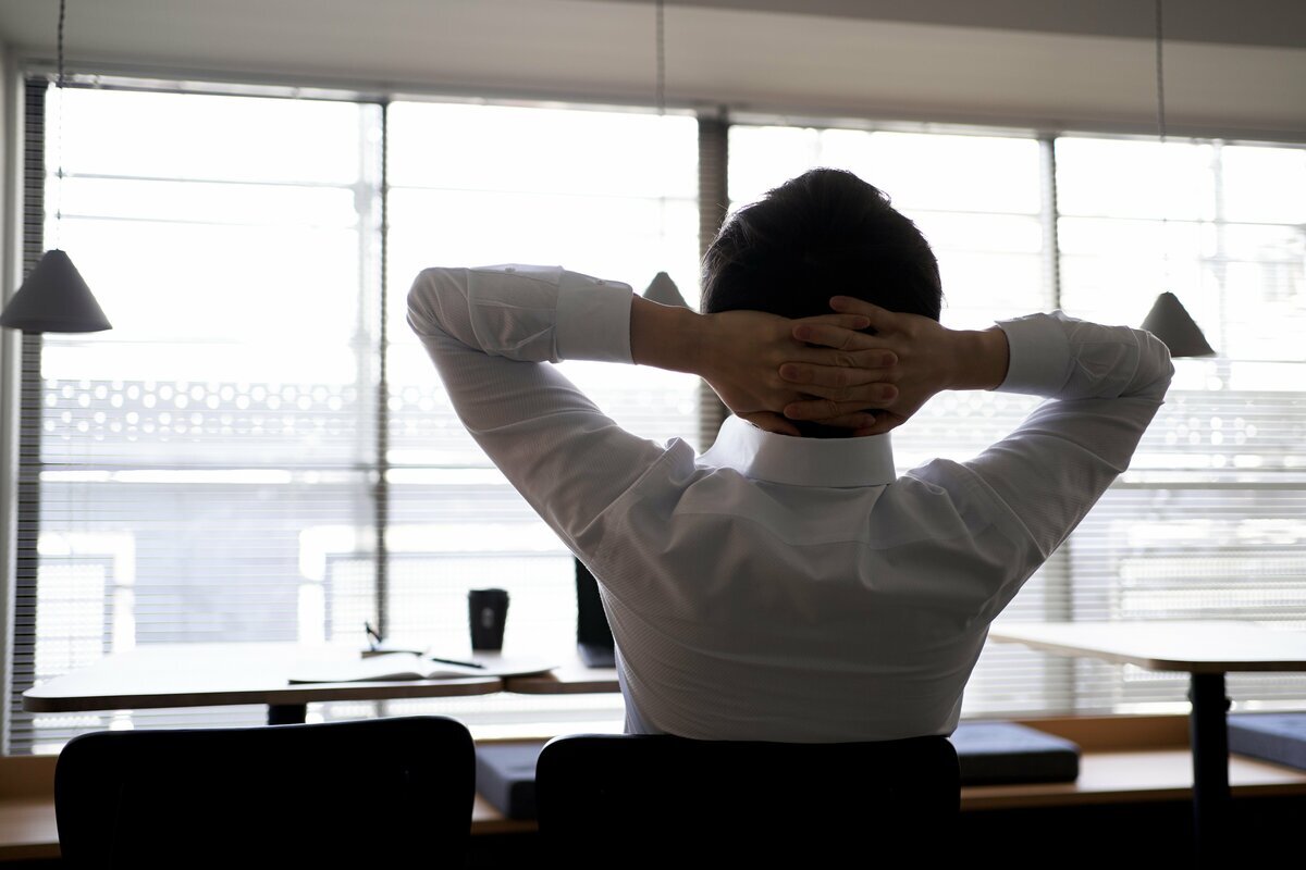 「静かな退職」の概念を象徴する、仕事に対する無気力な姿勢を示すビジネスパーソンのイメージ。