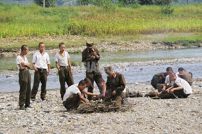 北朝鮮の郊外で盗んだトウモロコシを焼くやせ細った兵士たち。兵士の栄養状態の悪化を示す。
