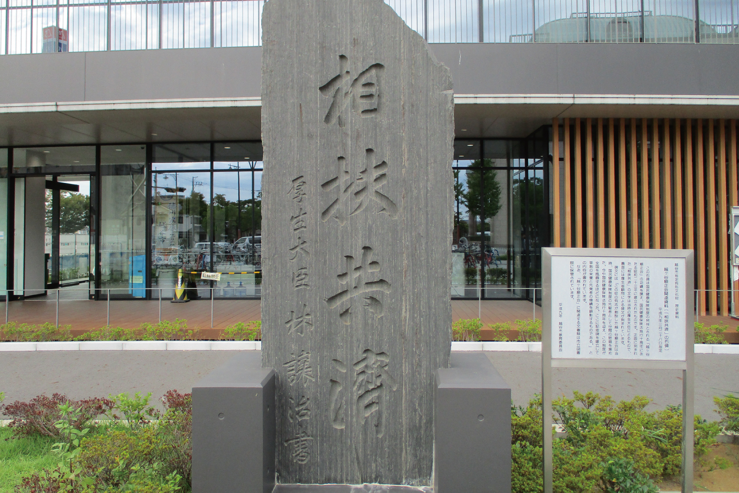 埼玉県越谷市役所前に立つ「相扶共済」の石碑。国民健康保険制度の相互扶助の精神を表す。