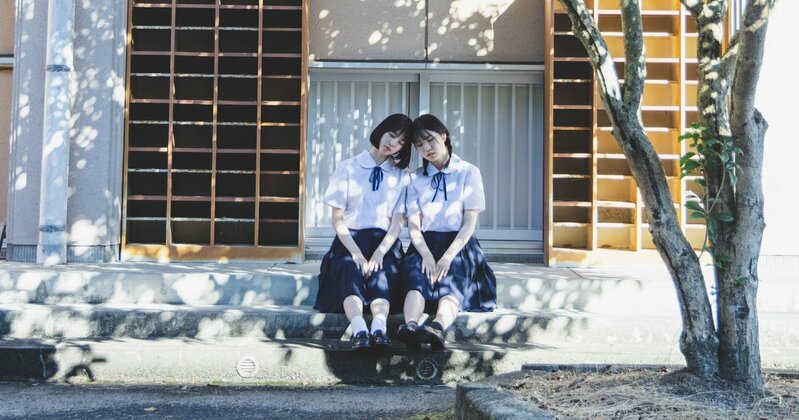 大学受験を控える学生の姿。机に向かい真剣に勉強する様子が、学歴や将来の選択肢への重圧を象徴している。