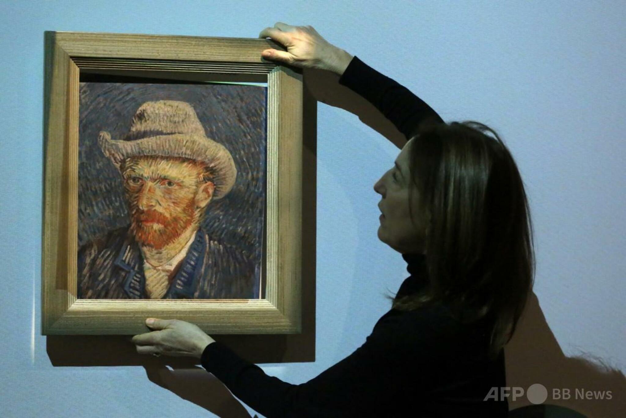 ゴッホ美術館館長が展示会「Choosing Vincent」で複製画の額縁を取り外す様子