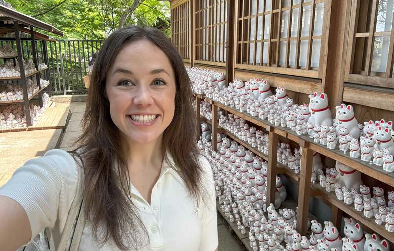 豪徳寺を訪れるハーバードビジネススクールの学生アレックス・リビングストン氏。招き猫で有名な寺院での日本文化体験の一コマ。