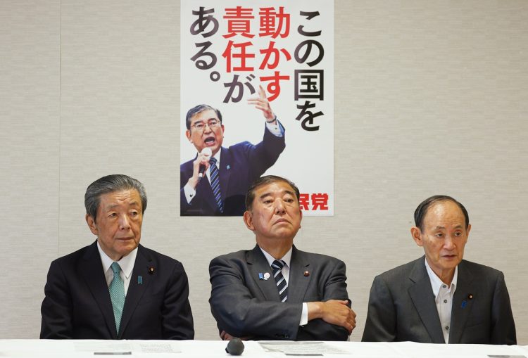 自民党本部での役員会に出席する石破茂首相と森山裕幹事長。石破政権の支持率と党内情勢を示す場面。