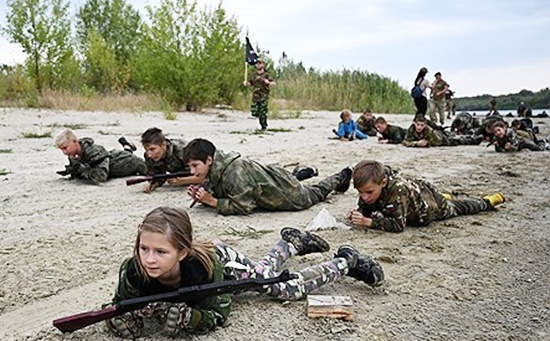 ロシア南部のドン川で、迷彩服を着て軍事訓練を受ける子どもたちの様子。ウクライナ戦争の退役軍人による指導で、愛国心教育の一環として行われるサマーキャンプの活動風景。