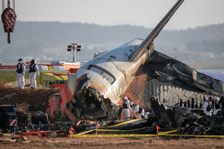 昨年12月31日、務安空港で発生したチェジュ航空7C2216便の事故現場を詳細に調査する韓国警察の科学捜査隊。周辺のコンクリート構造物が事故原因との関連性も視野に入れている。