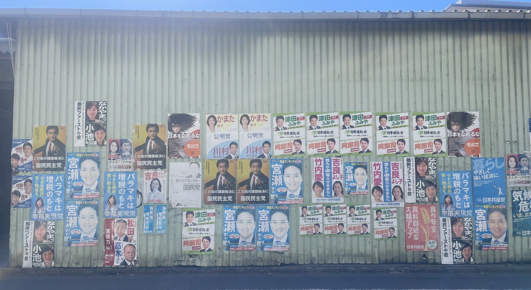 東京都板橋区の倉庫壁面にひしめき合う複数の政党ポスター。「オールスター」と称される選挙ポスターの競争状況を示す。