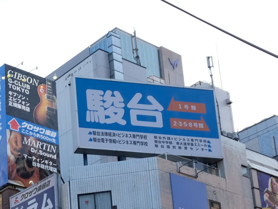 駿台予備学校の看板が立つ街並み。2026年度からの大学入試合格者数公表中止の方針を示す。