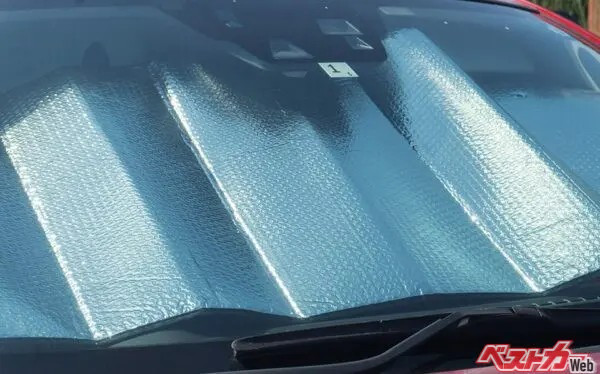 猛暑日の車内で快適なエアコン設定を模索するドライバー