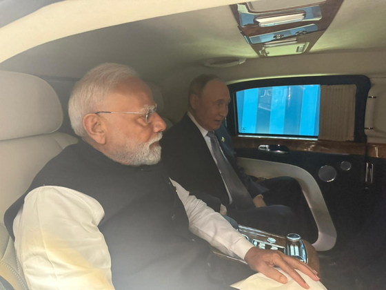 SCO首脳会議のため天津に到着し、同じ車で会談場へ向かうインドのモディ首相（左）とロシアのプーチン大統領。両首脳は中国が提唱するSCO開発銀行の設立を支持した。