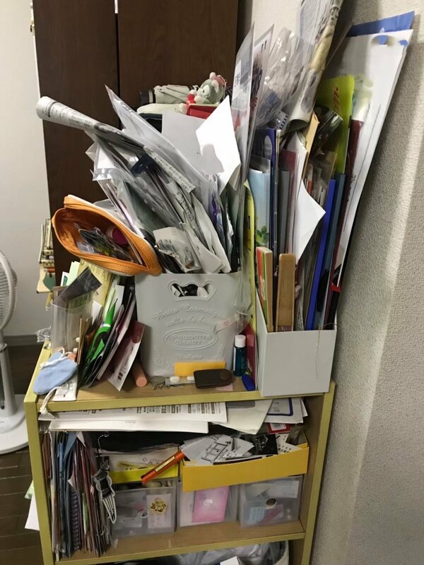 片付けられずに積み重なった大量の書類や紙の山。必要な情報が見つからないストレスと散らかった状態を表現しています。