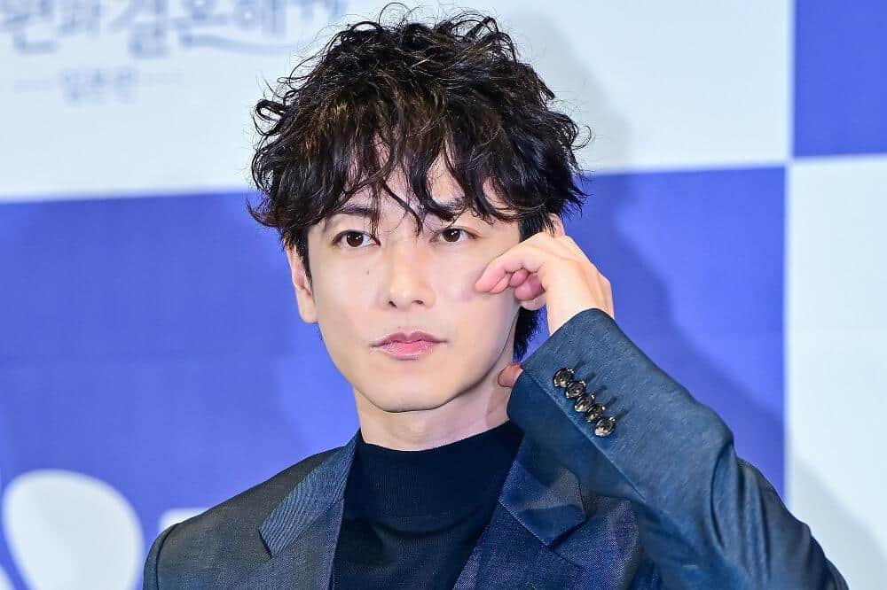 スーパーマーケットの前に立つ俳優・佐藤健さん
