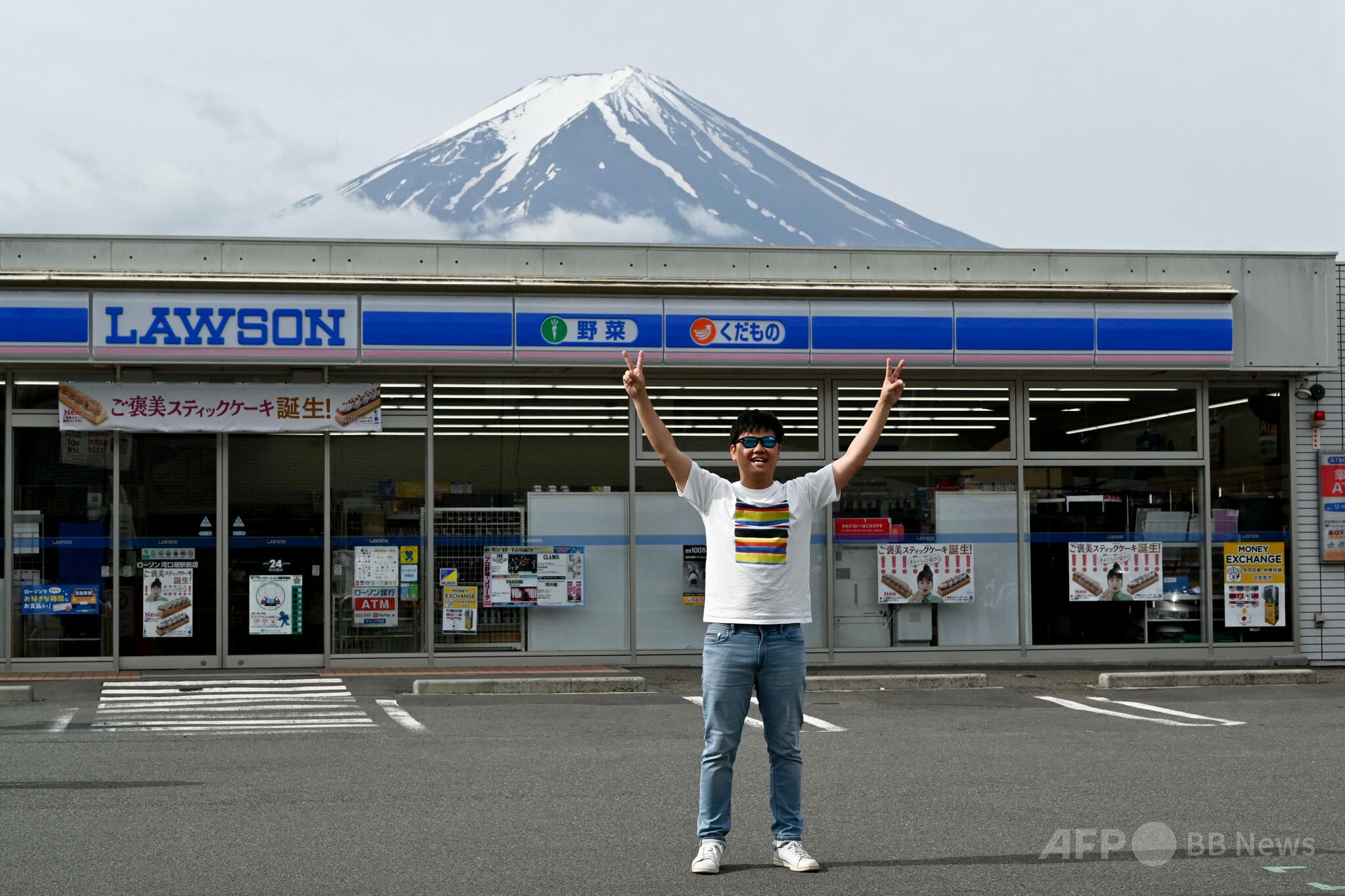 富士山と外国人観光客の観光マナー問題を示す山梨県富士河口湖町のコンビニエンスストア前の様子