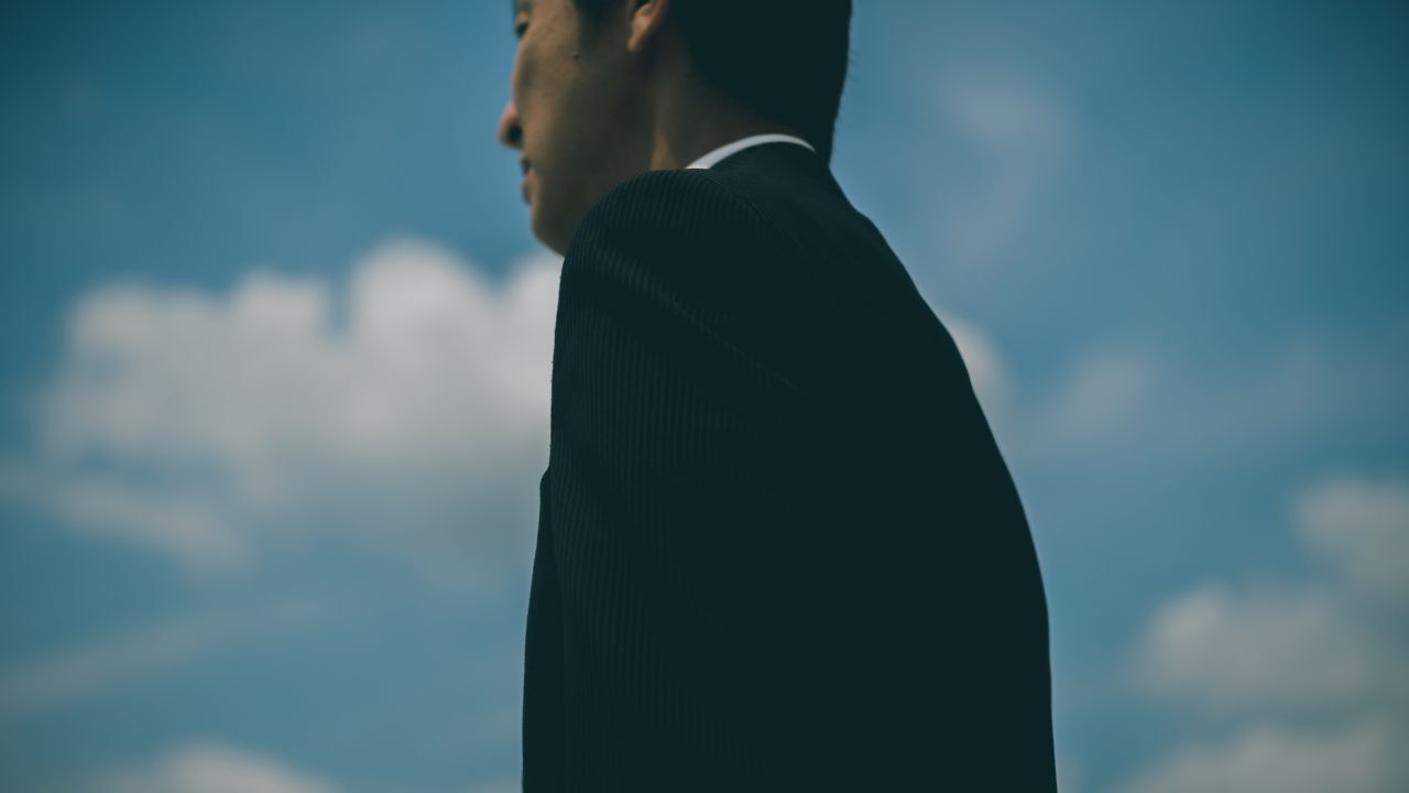 老後資金や早期退職について思い悩む中高年サラリーマンの様子
