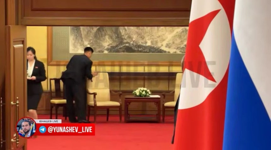 プーチン大統領との会談後、金正恩氏が座った椅子を清掃する北朝鮮随行員。生体情報保護の徹底か。