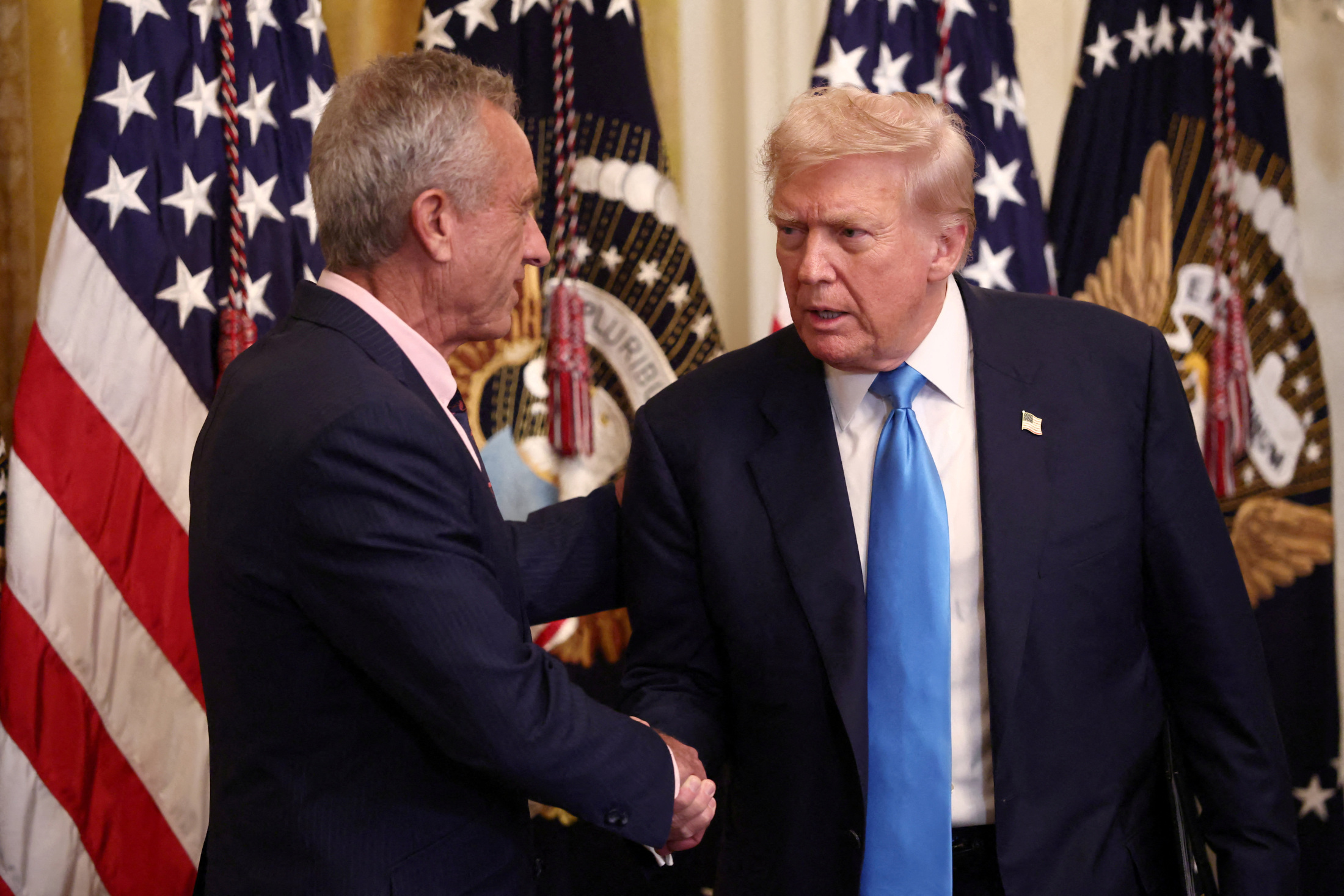米上院公聴会で批判されるケネディ厚生長官。写真はトランプ大統領と握手する同氏
