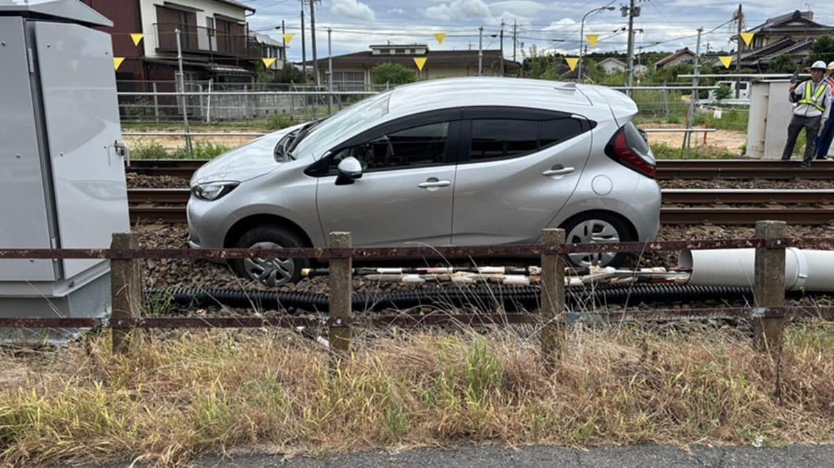 名鉄小牧線春日井駅付近の踏切で線路上に進入し立ち往生した高齢ドライバーの車と、事情聴取を受ける男性