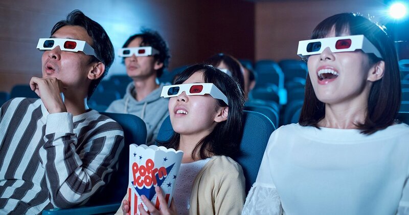 値上げされた映画鑑賞料金を支払い、日本の映画館で映画を楽しむ観客のイメージ。