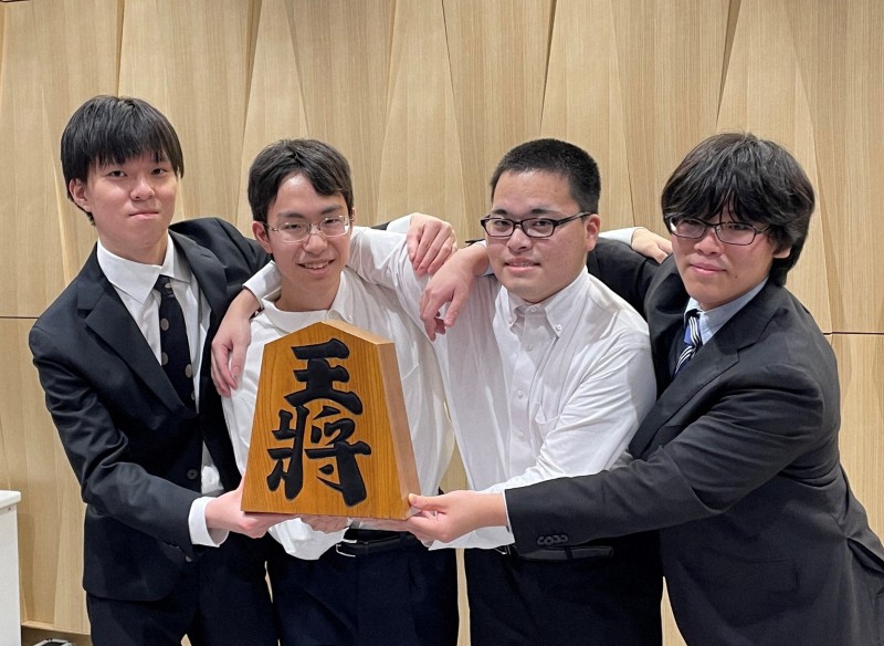 将棋奨励会で四段昇段を果たした片山史龍、岩村凜太朗、生垣寛人、山下数毅の4新四段が将棋会館で記念撮影に応じる様子