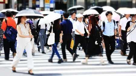 記録的な猛暑の中、男性も日傘で紫外線対策を行う様子