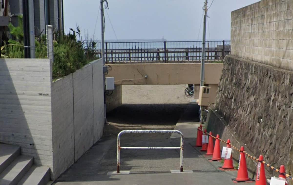 逗子海岸に無許可侵入し、砂浜でスタックした白い高級車と車止め
