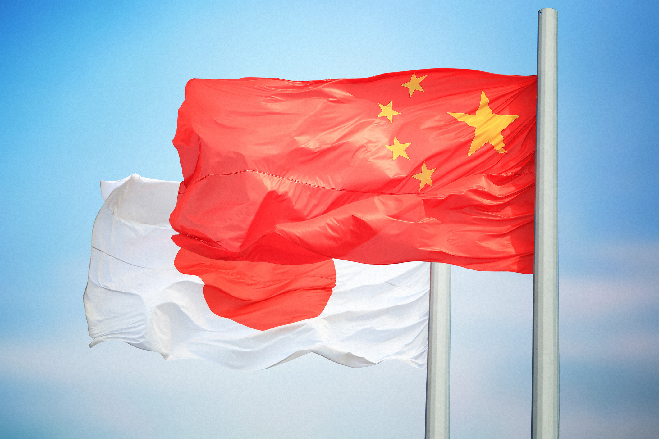 日中関係の象徴として並ぶ日本と中国の国旗。石破首相辞意表明後の両国関係の行方を暗示する。