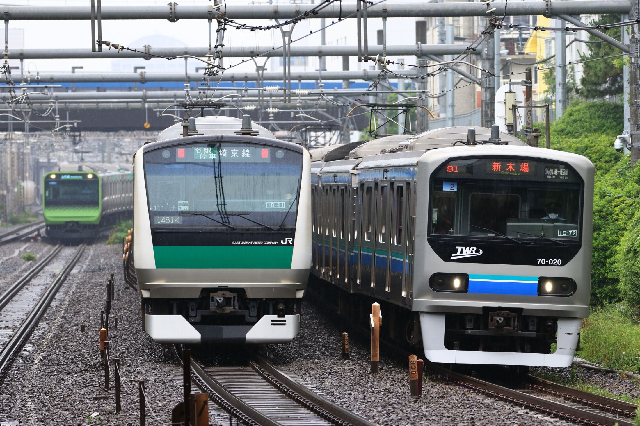 満員電車の中で苦悶の表情を浮かべるサラリーマンと駅員