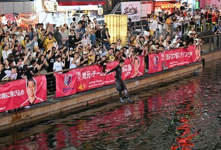 2025年セ・リーグ連覇を祝し、道頓堀川に飛び込む熱狂的な阪神タイガースファン
