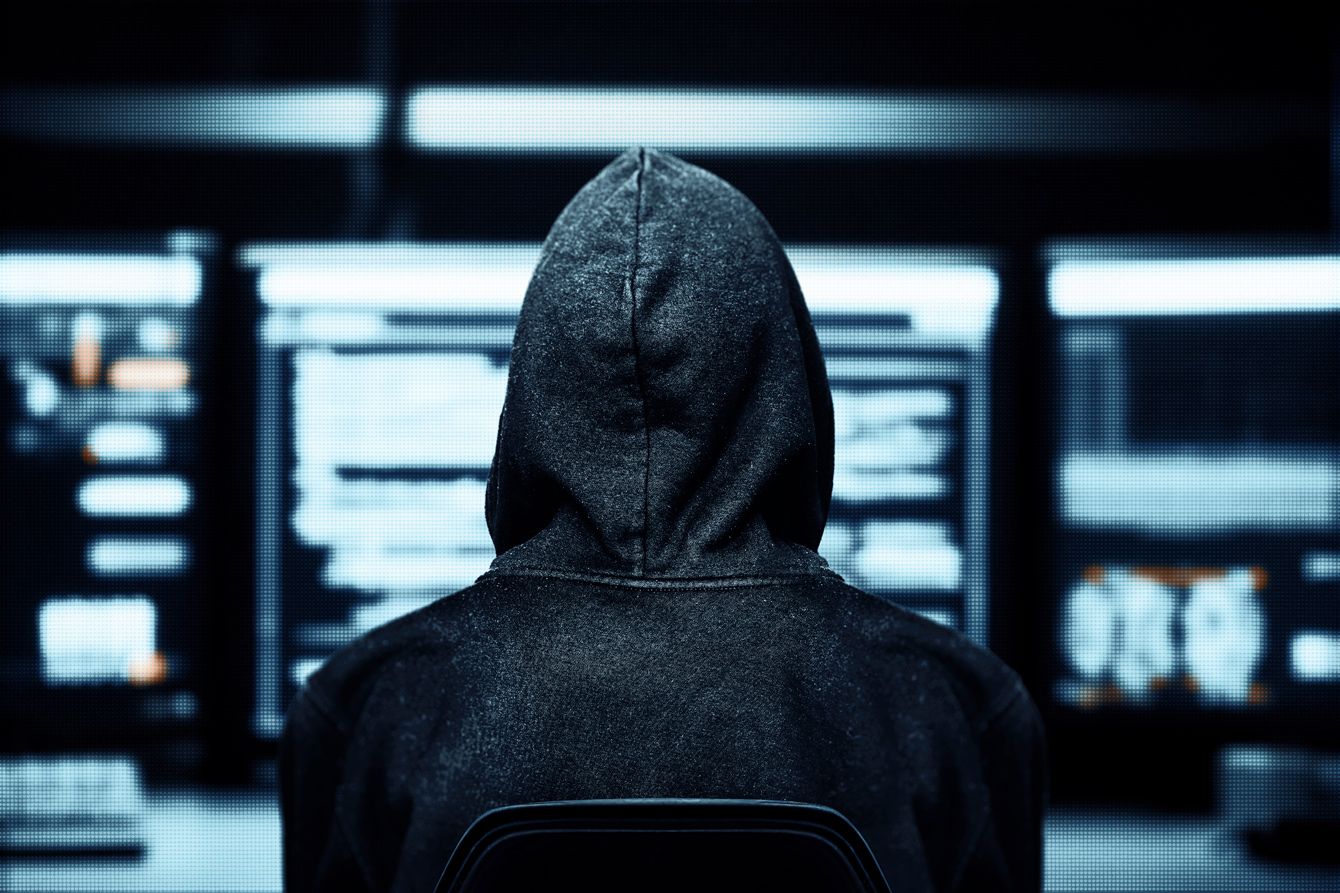 サイバー攻撃のリスクを示す暗闇の中で光るPC画面のイメージ