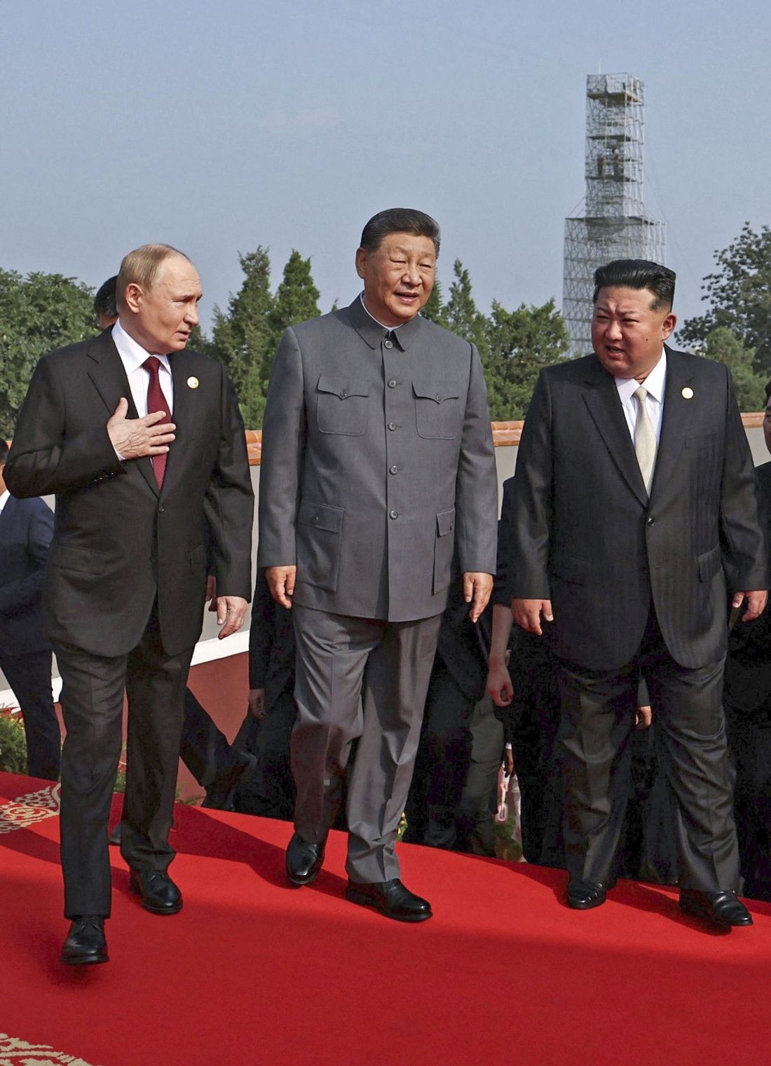 中国の抗日戦勝記念軍事パレードに出席し、並んで立つ習近平、プーチン、金正恩。強権的な指導者たちの連帯を示す場面。