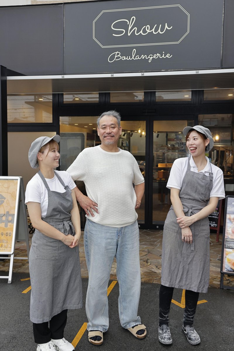 今年11月で創業5周年を迎えるパン店「ブーランジェリーショー」の店頭で記念撮影する髙田舞美さん、川端優里さん、川端正悟さん