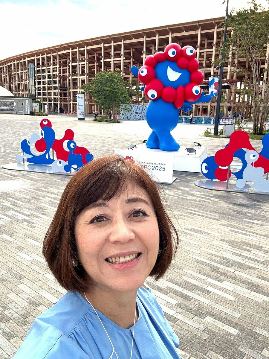大阪・関西万博の会場でミャクミャクと一緒にポーズをとる筆者