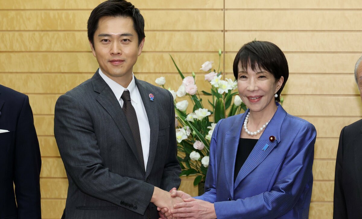 首相に選出された高市早苗氏（右）と日本維新の会の吉村代表が、連立交渉後に握手を交わす様子。憲政史上初の女性首相となる高市氏と、政策実現を掲げる維新の協力関係を示す一枚。
