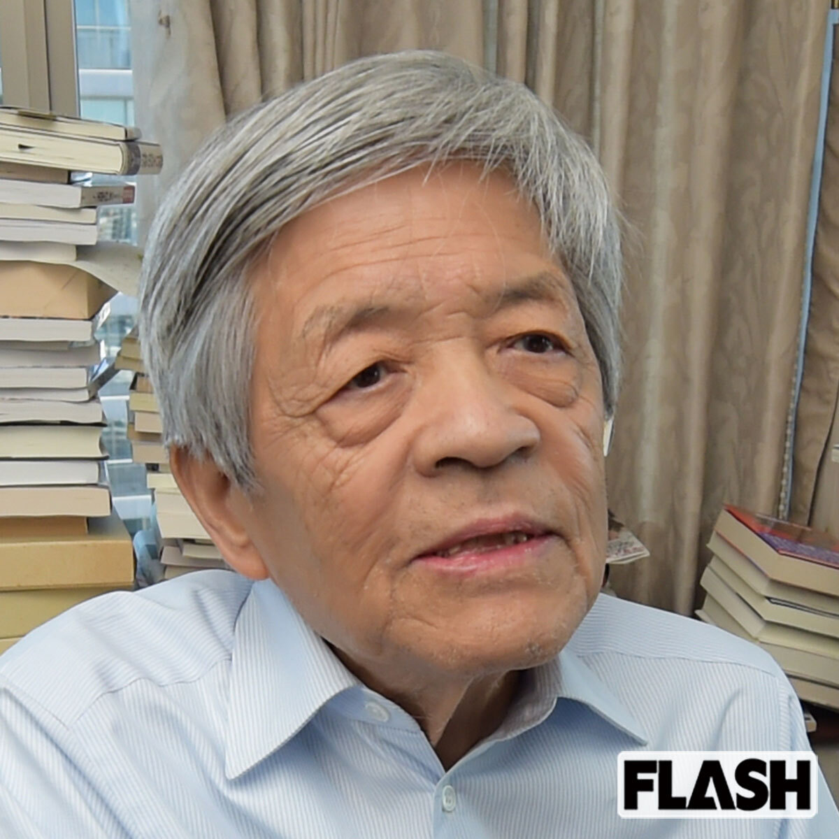 本棚に囲まれた書斎で思案顔のジャーナリスト田原総一朗氏
