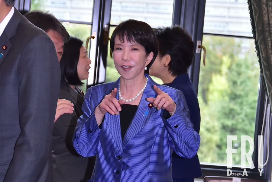 高市早苗首相がカメラの前で笑顔を見せる。新しい高市政権の顔としての親しみやすさを示す瞬間。