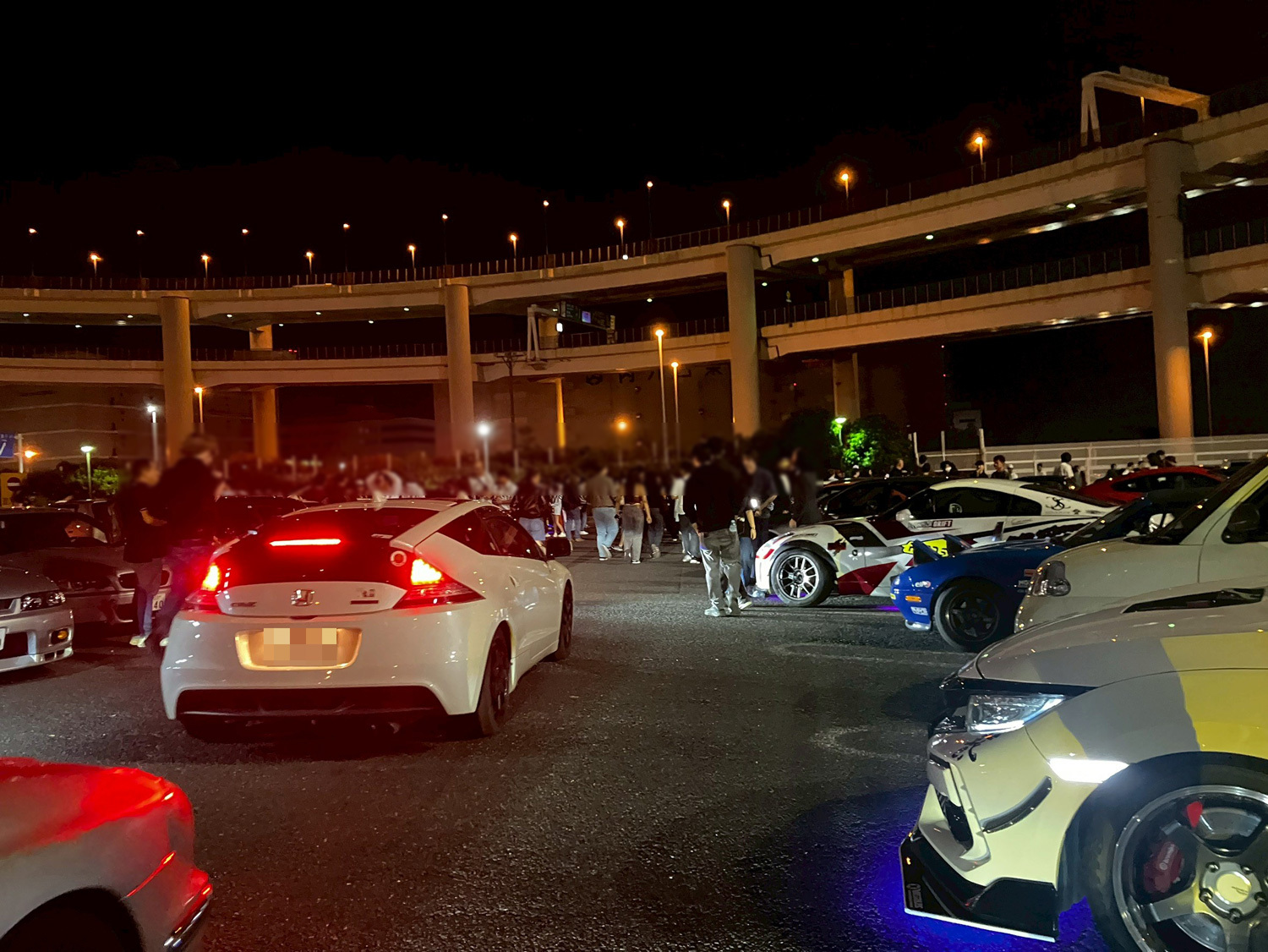 外免切替厳格化後も?大黒PAで外国人ドライバーの「爆走族」化が加速する背景と危険性 大黒PAに集まり車を見物する外国人ドライバーたち