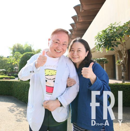 高須克弥氏と西原理恵子氏が都内ホテルで満面の笑顔を見せ、「Yesポーズ」を取る様子。長年の絆と闘病を支え合う二人の幸福な瞬間を象徴しています。