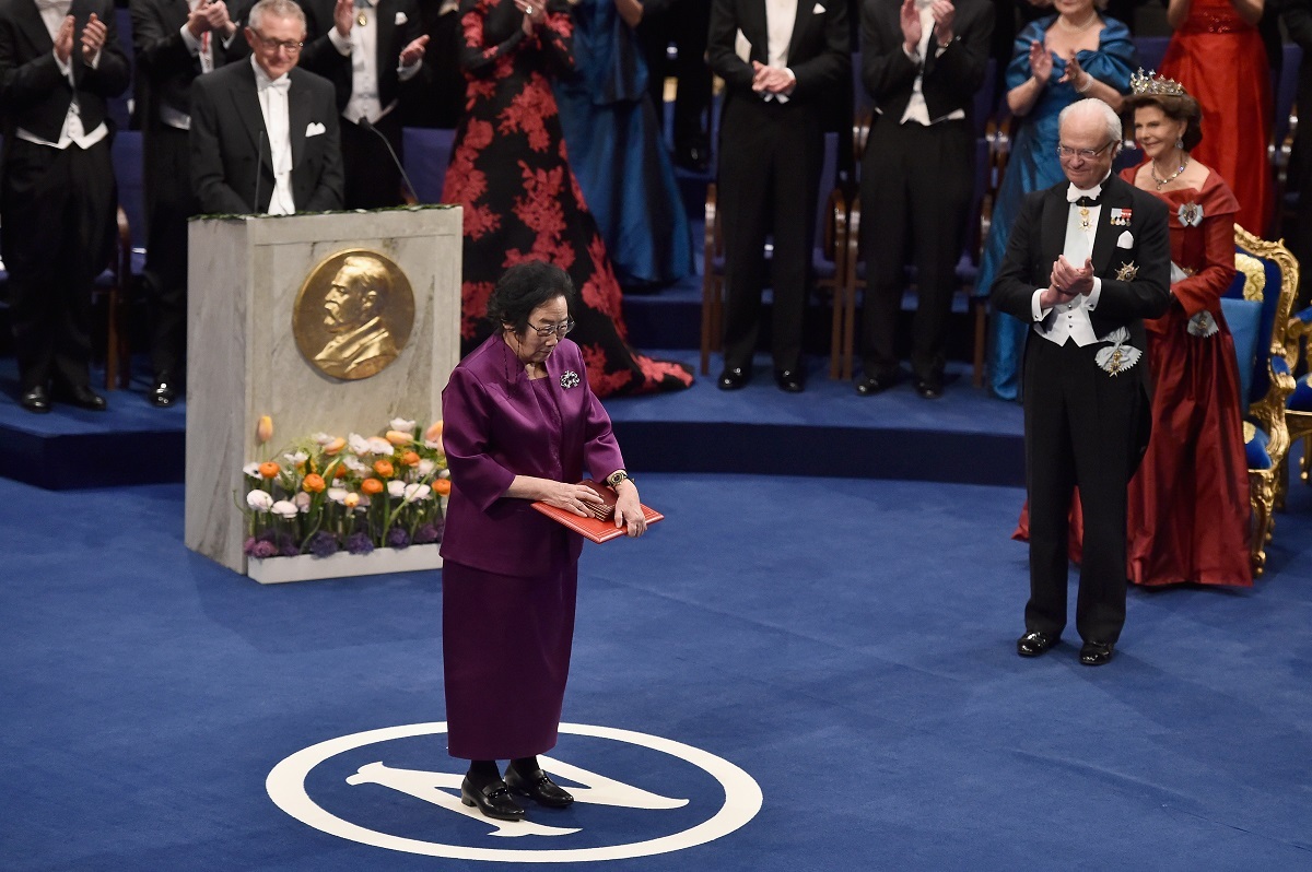 2015年にノーベル賞を受賞した中国の薬学者、屠呦呦氏が授賞式で国王から賞状を受け取る様子