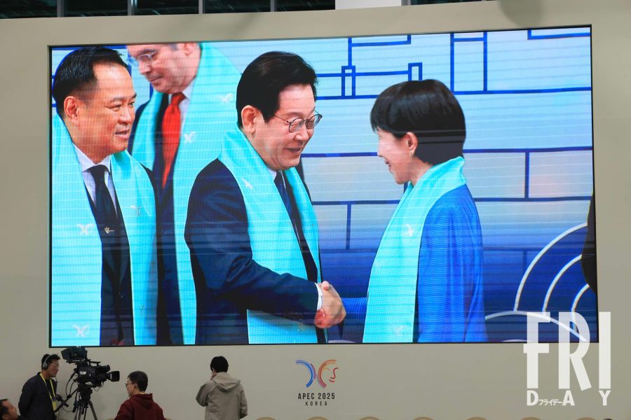 APEC閉幕時、メディアセンターのスクリーンに映し出された高市総理と李大統領の握手