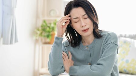 仕事や家事に追われる女性が疲労を感じている様子