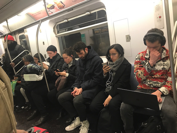 ここ数年のいつもの地下鉄の光景。横一列全員がスマホを扱っている（ラップトップで作業している人も）。 (c) Kasumi Abe