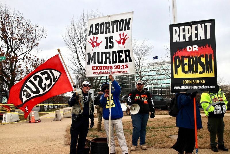 「人工中絶は殺人」と書いたプラカードで抗議する人々（2021年）。(c) Kasumi Abe