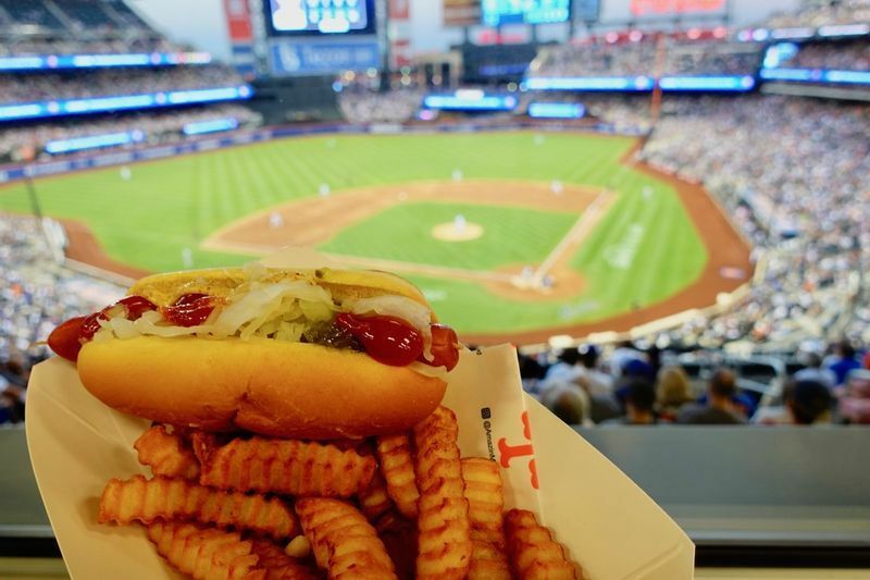 ホットドッグとフレンチフライ（14.25ドル、約1950円）。球場ということで値段が高めだが、この雰囲気の中で食べるホットドッグは美味しさが増す！(c) Kasumi Abe
