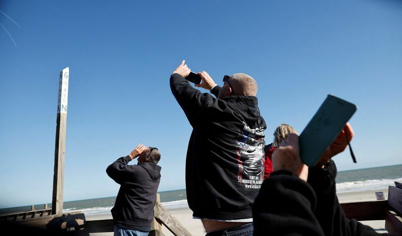 4日、サウスカロライナ州の海岸で、偵察気球の撃墜の瞬間を撮影する人々。