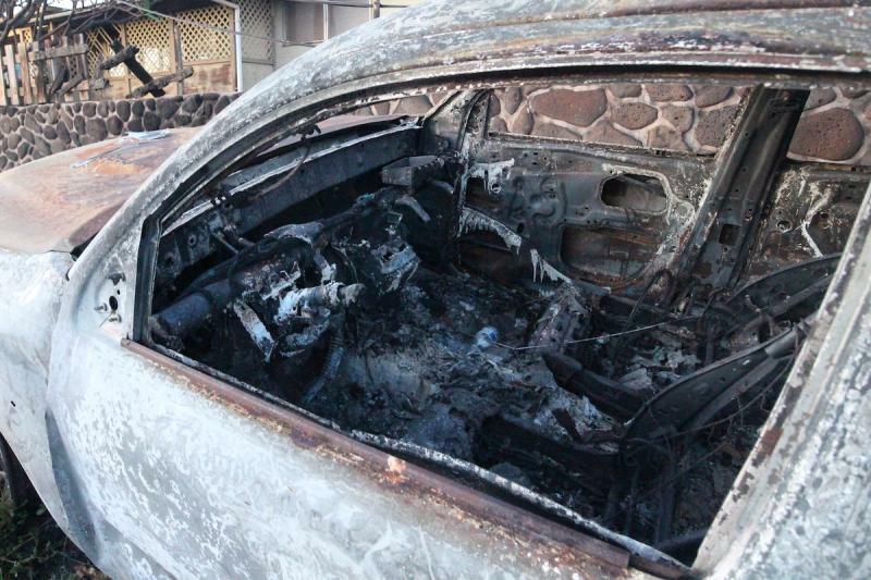 道路に放置されたままの焼け焦げた車両。(c)Kasumi Abe